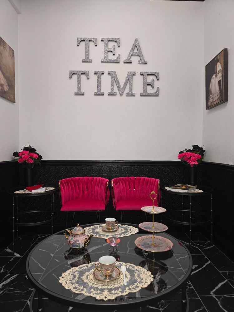 A private tea room with pink velvet seating and floral tea service